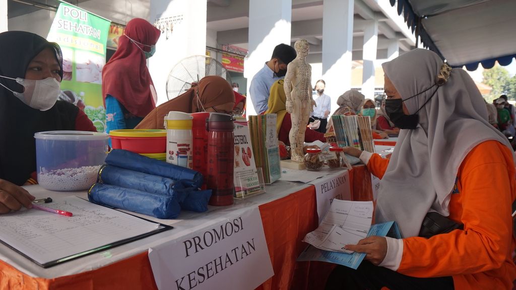 Warga mendapatkan informasi promosi kesehatan saat Bakti Sosial Layanan Terintegrasi di Pasar Gunung Anyar, Surabaya, Jawa Timur, Jumat (22/7/2022). 