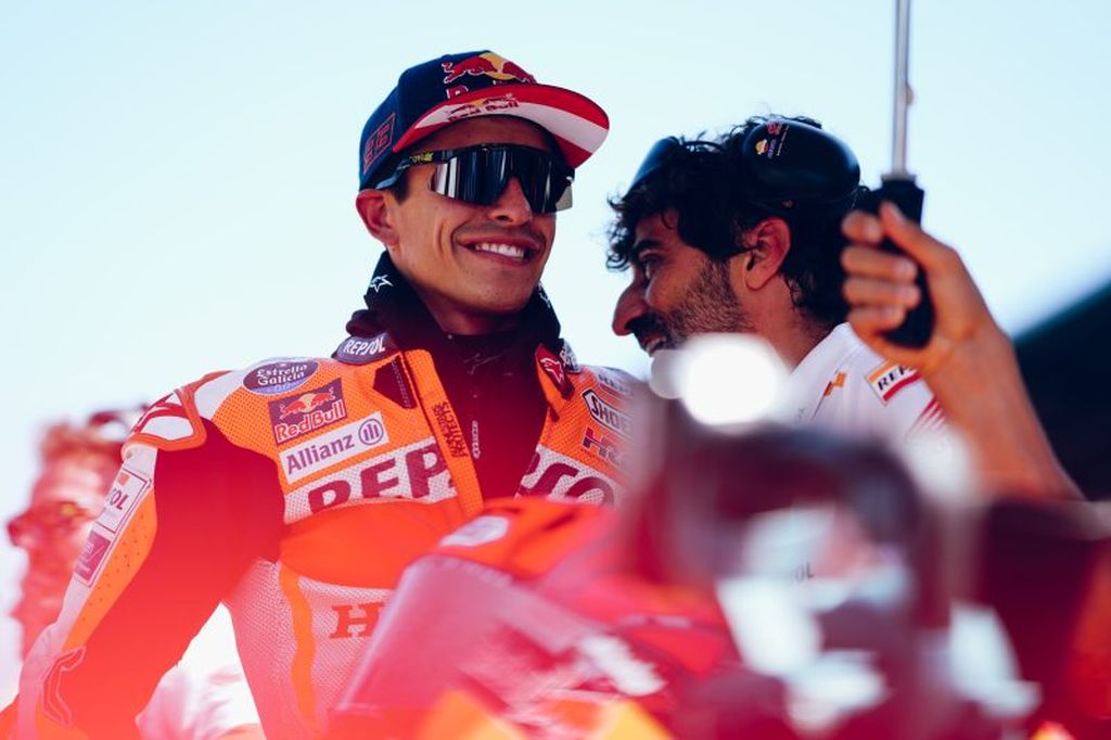 Marc Marquuez tersenyum dalam percakapan dengan kepala mekaniknya, Santi Hernandez, di garis start menjelang balapan MotoGP seri Austria di Sirkuit Red Bull Ring, Spielberg, Minggu (20/8/2023). 
