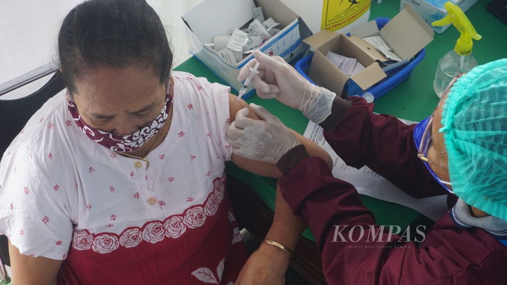 Seorang warga lansia menerima vaksinasi penguat atau <i>booster</i>, Covid-19, di RSUD Ibu Fatmawati Soekarno, Kota Surakarta, Jawa Tengah, Jumat (14/1/2021). Ini merupakan hari pertama digelar vaksinasi penguat di kota tersebut. Target sasaran awal terdiri dari 55.000 lansia.