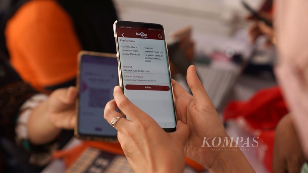 Warga membayar dengan memindai QRIS dalam acara Gerakan Pangan Murah di halaman Balaikota DKI Jakarta, Jakarta Pusat, Senin (17/4/2023). Pembayaran dengan memindai QRIS melalui aplikasi JakOne <i>mobile</i> mendapatkan potongan diskon hingga 62 persen. 