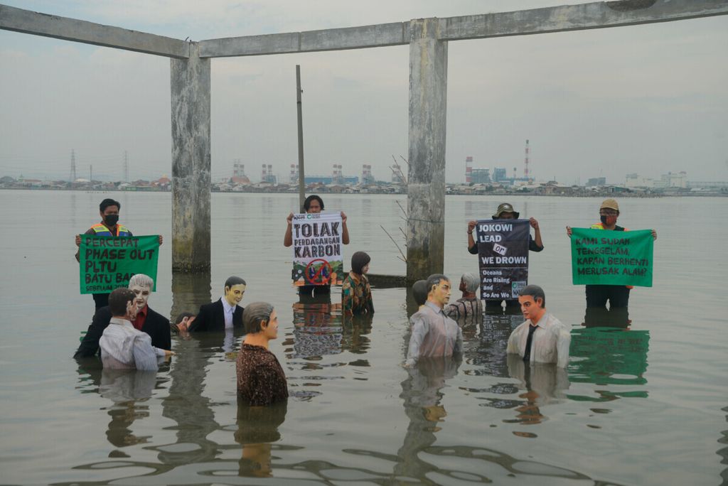 Aktivis Wahana Lingkungan Hidup Indonesia (Walhi) Jawa Tengah beserta komunitas membentangkan poster berisi kritik kepada pemerintah tentang persoalan lingkungan di Tambakrejo, Kota Semarang, Jawa Tengah, Jumat (5/11/2021).