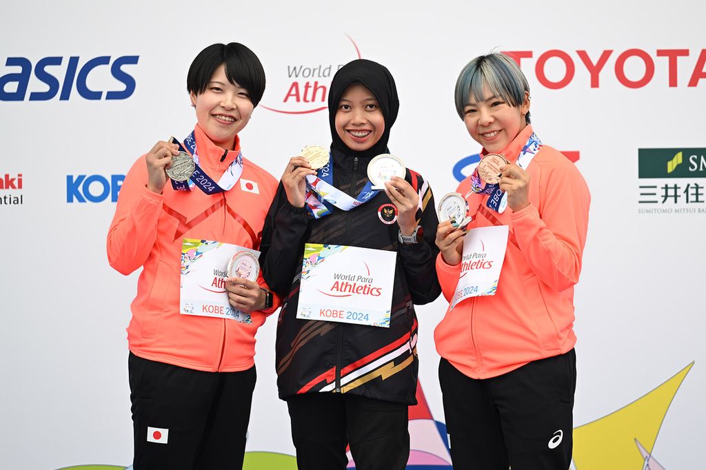 Indonesian female sprinter, Karisma Evi Tiarani (center), poses with the medal she won during the medal ceremony for the women's 100-meter T37 event at the Kobe 2024 Para Athletics World Championships at Kobe Universiade Memorial Stadium in Kobe, Japan, on Wednesday (22/05/2024).