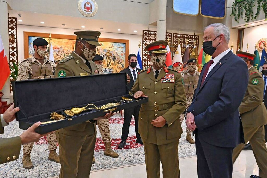Menteri Pertahanan Israel Benny Gantz (mengenakan jas warna hitam) menerima cinderamata dari Panglima Angkatan Bersenjata Bahrain, Marsekal Shaikh Khalifa bin Ahmed Al Khalifa (tengah)  saat kunjungan Gantz ke Manama, Bahrain pada 3 Februari 2022 lalu. 