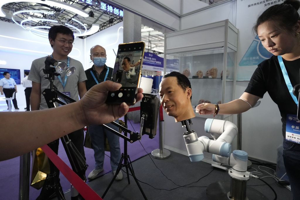 Seorang pengunjung merekam video kepala seseorang yang tampak hidup guna menguji teknologi biometrik dengan telepon pintarnya pada ajang Security China 2023 di Beijing, China, 7 Juni 2023.