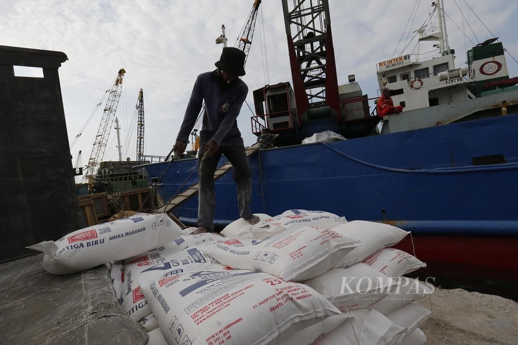 Buruh membongkar tepung terigu yang akan dikirim ke Pulau Natuna, Kepulauan Riau, dengan menggunakan kapal di Pelabuhan Sunda Kelapa, Jakarta, 30 Juni 2023. 