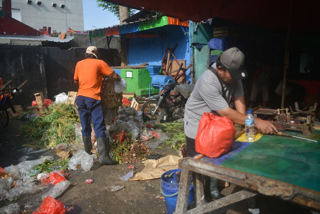 Petugas kebersihan mengumpulkan sampah sisa berjualan di Pasar Palmerah, Kelurahan Gelora, Kecamatan Palmerah, Jakarta Pusat, Senin (3/10/2022).