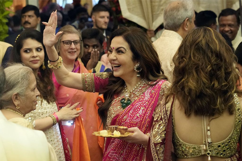 Nita Ambani (tengah), istri Pemimpin Reliance Industries Chairman Mukesh Ambani, menyambut tamu-tamunya dalam upacara pernikahan putra bungsunya, Anant Ambani, dengan Radhika Merchant, di kediaman Antilia di Mumbai, India, 3 Juli 2024. Mukesh Ambani adalah salah satu orang terkaya di dunia. 