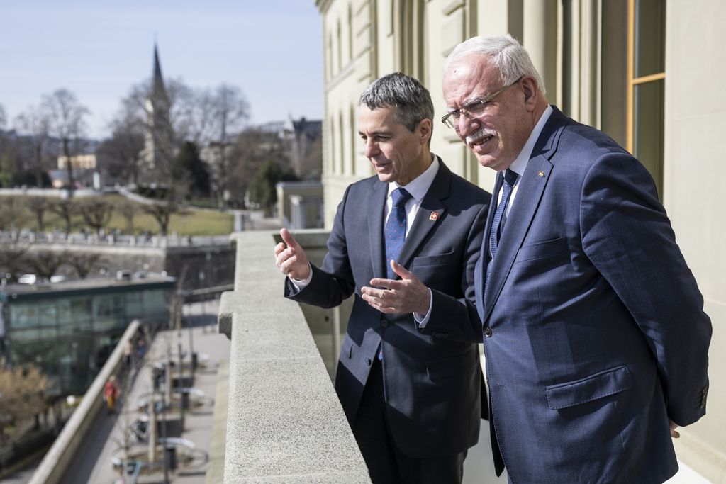 Presiden Swiss Ignazio Cassis (kiri) menjelaskan pemandangan yang mereka lihat dari balkon kediamannya kepada tamunya, Menteri Luar Negeri dan Ekspatriat Palestina Riad Malki, di Bern, Swiss, 2 Maret 2022.