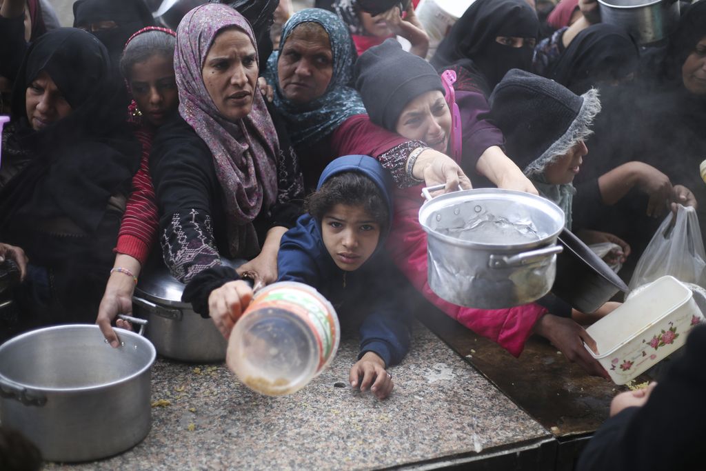 Warga Gaza mengantre jatah makanan pada Jumat (2/2/2024).  Mayoritas warga Gaza terpaksa mengandalkan bantuan karena perekonomian Gaza tidak mungkin berjalan akibat serangan Israel. 
