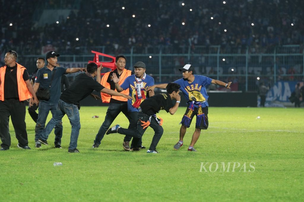 Aremania (suporter Arema FC) merangsek turun menuju lapangan dalam Liga Satu 2018 antara Arema FC dan Persib Bandung, Minggu (15/4/2018), di Stadion Kanjuruhan Malang, Jawa Timur. Laga berakhir rusuh dalam kedudukan 2-2 setelah suporter merangsek masuk ke dalam lapangan.