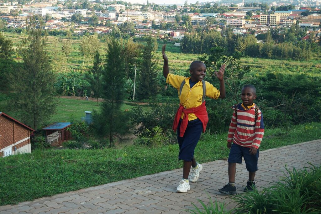 Dua anak berjalan sepulang sekolah di kota Kigali, Rwanda, Rabu (1/4/2024). Rwanda dinobatkan sebagai negara terbersih di Afrika sebagai buah kegigihan warganya menjaga kebersihan.