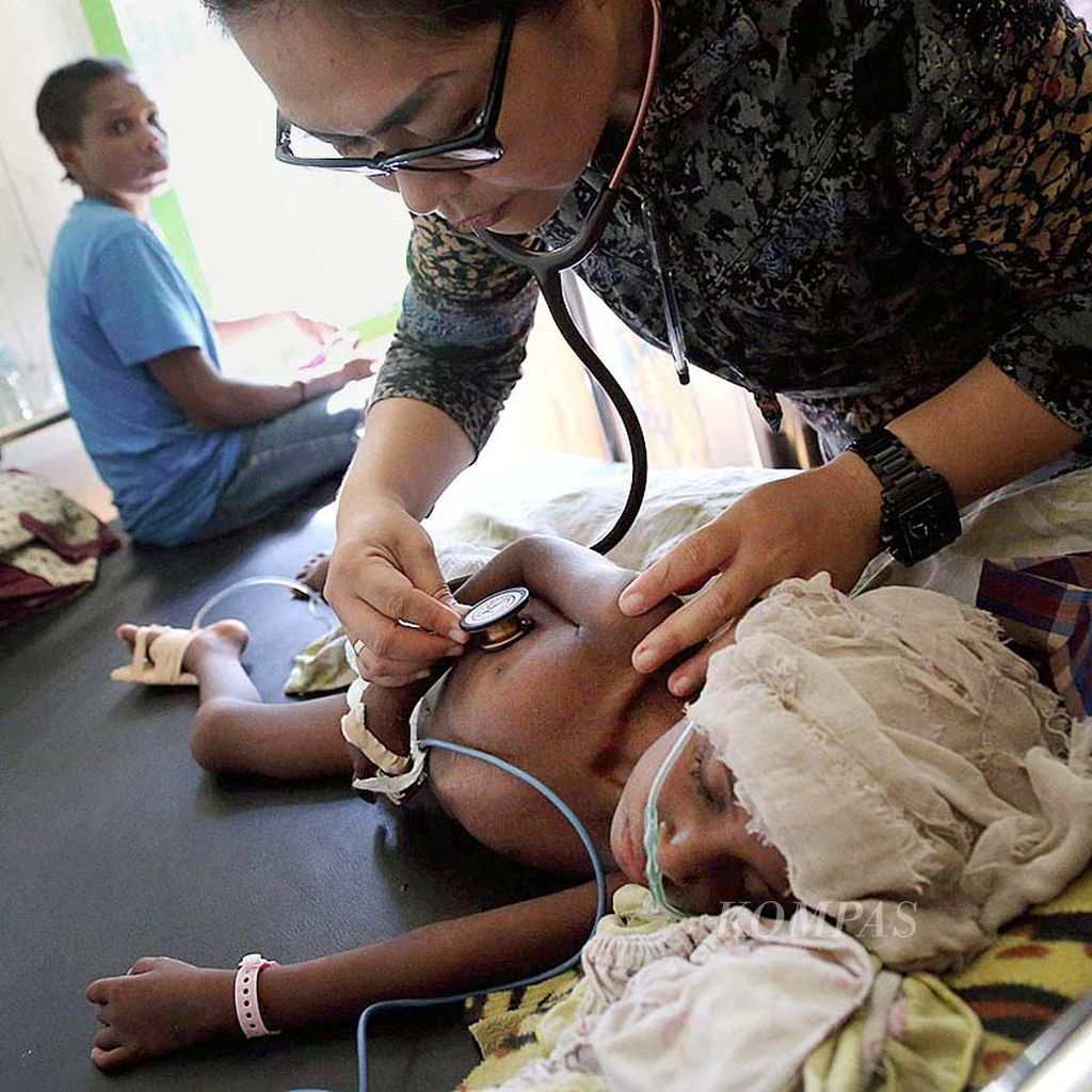 Dokter Carol Jaqueline  memeriksa seorang anak yang dirawat di RSUD Agats, Papua, karena menderita campak dan gizi buruk, Jumat (12/1). Sepanjang Januari ini,  RSUD Agats melayani 34 pasien rawat jalan dan 29 pasien rawat inap penderita campak dan gizi buruk.