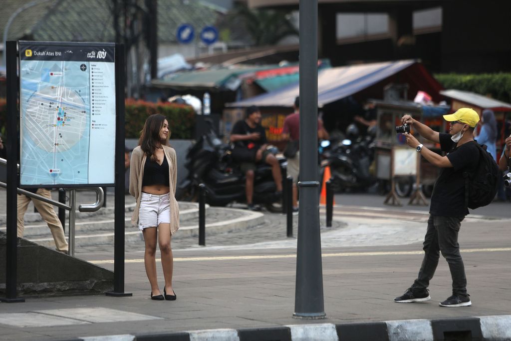 Fotografer memotret seorang perempuan yang bergaya di sekitar di Taman Stasiun MRT Dukuh Atas, Jakarta, Jumat (8/7/2022). Saban sore menjelang senja, kawasan ini selalu ramai dengan hadirnya remaja usia belasan tahun dengan pakaian mencolok dari sejumlah daerah sekitar Jakarta, seperti Citayam, Bogor, dan Depok. 