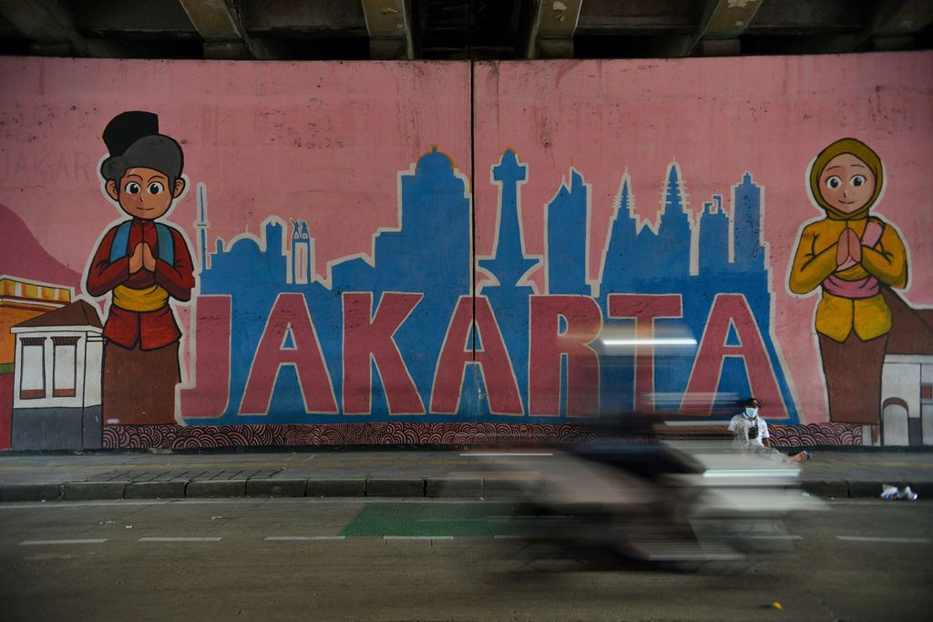 Seorang pengendara sepeda motor melintas di samping mural tentang Jakarta di sekitar Stasiun Jatinegara, Jakarta Timur, Rabu (18/1/2023). 