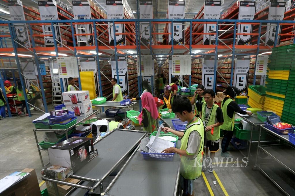 Karyawan mendata dan menyiapkan barang pesanan untuk dikirimkan kepada pembeli di gudang penyimpanan milik situs belanja daring Lazada Indonesia di kawasan Jatijajar, Depok, Jawa Barat, Desember 2017.