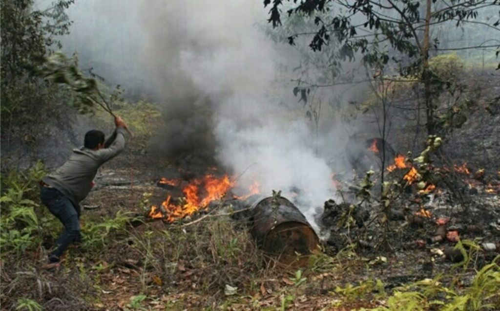 Warga memadamkan kebakaran lahan di Kabupaten Mappi, Papua Selatan, pada 11 September 2019. dengan peralatan seadanya. 