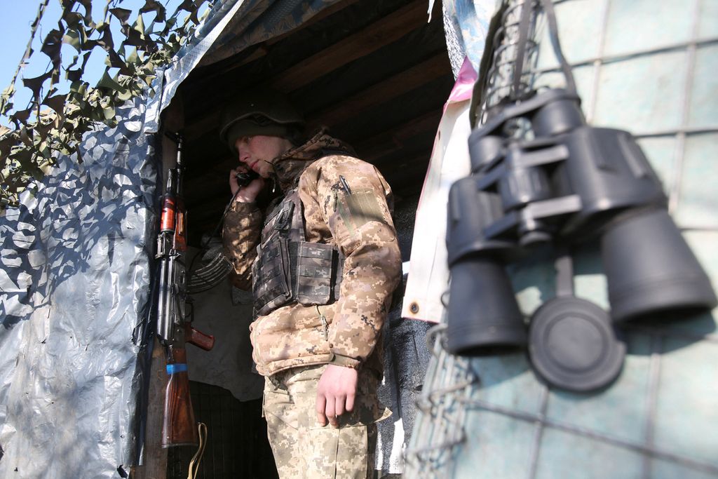 Seorang prajurit pasukan militer Ukraina yang berada di garis depan membuat panggilan di dekat desa Novognativka, wilayah Donetsk, Ukraina, Senin (21/2/2022). Donetsk merupakan wilayah di Ukraina timur yang dikuasai oleh kelompok separatis dukungan Rusia. 