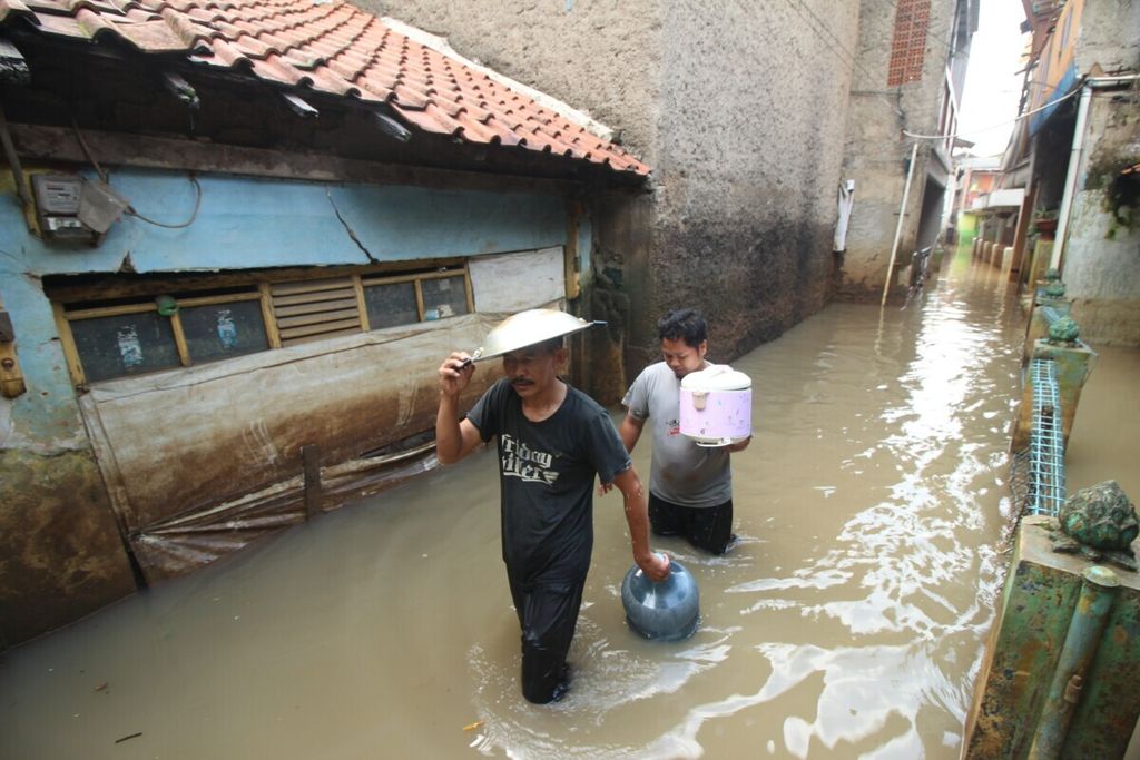 Warga di Kelurahan Andir, Kecamatan Baleendah, Kabupaten Bandung, Jawa Barat, membawa panci, galon air, dan penanak nasi untuk mengungsi, Selasa (28/1/2020). Meskipun banjir akibat luapan Sungai Citarum dan anak sungainya berangsur surut, lebih dari 1.000 warga di Kecamatan Baleendah, Dayeuhkolot, dan Bojongsoang masih mengungsi.