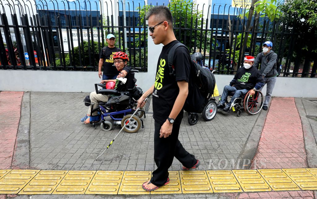 Sejumlah anggota gerakan Penyandang Disabilitas dan Lanjut Usia (Dilans) Indonesia melintas di trotoar jalan Sisingamangaraja, Jakarta Selatan, saat memperingati Hari Kursi Roda Internasional 2023, Rabu (1/3/2023). 