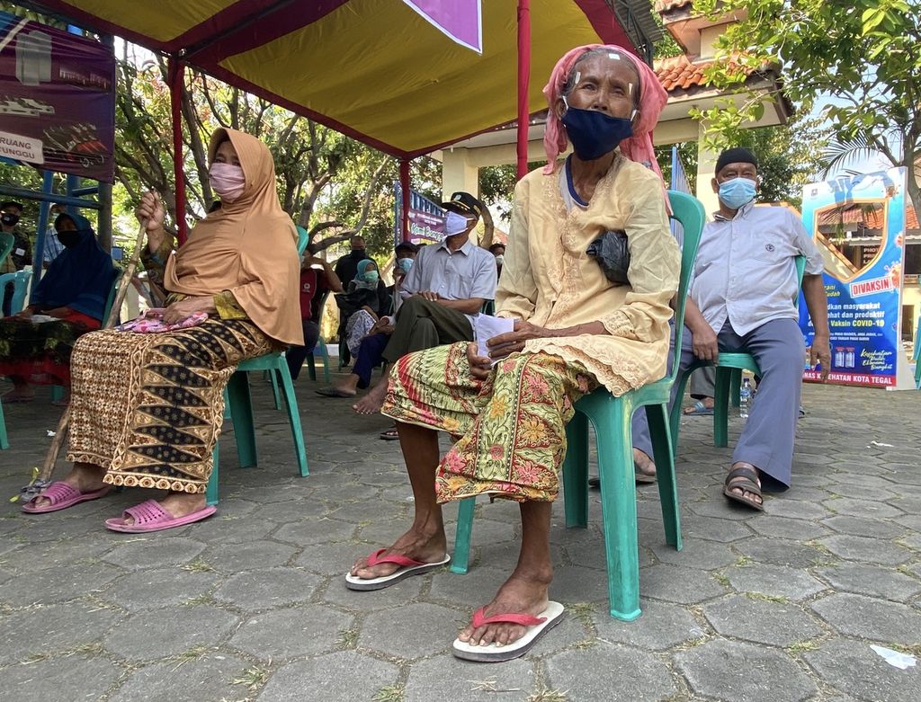 Para lansia mengantre untuk menjalani pemeriksaan kesehatan sebelum divaksin di halaman Kelurahan Kaligangsa, Kecamatan Margadana, Kota Tegal, Jawa Tengah, Kamis (10/6/2021). 