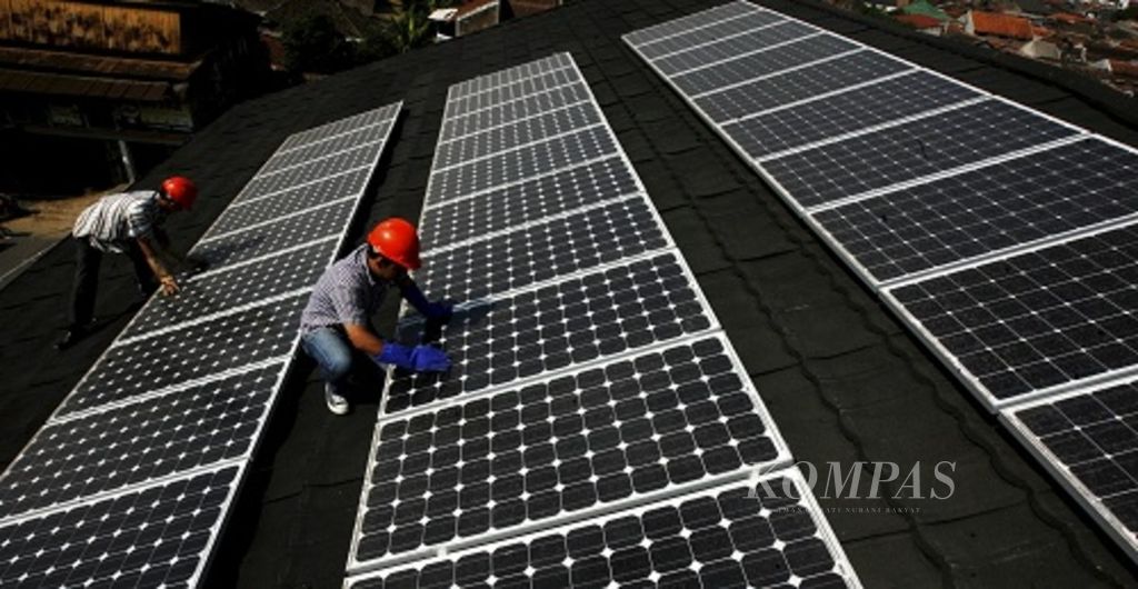Petugas PLN memeriksa panel surya yang terpasang di salah satu rumah warga di Jalan Citamiang, Bandung, Jawa Barat, yang juga berfungsi sebagai PLTS <i>rooftop</i>, Jumat (7/8/2015).