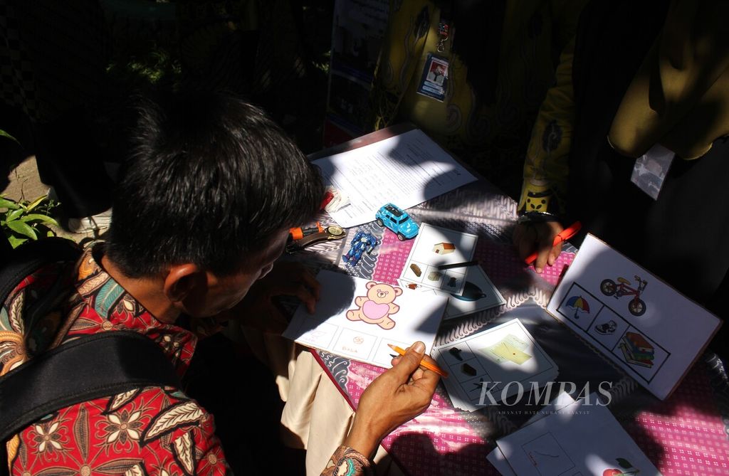 Seorang guru mencoba menuliskan ejaan kata di stan fonologi dalam Festival Belajar Kabupaten Muara Enim, Sumatera Selatan, Sabtu (17/6/2023). 
