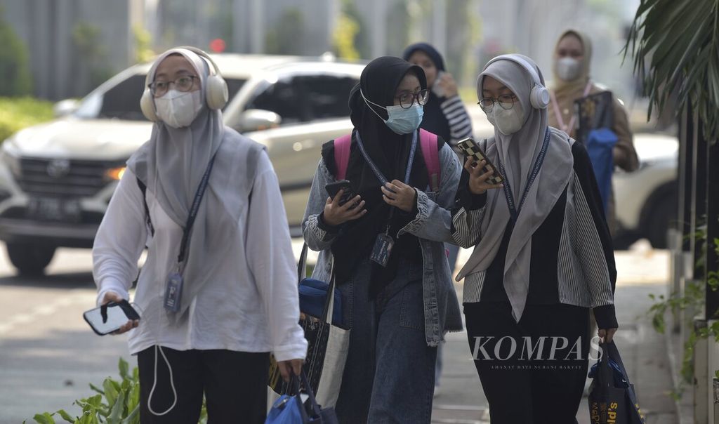Para pekerja kantor yang mengenakan masker berjalan kaki di jalur pedestrian Jalan Kyai Maja, Jakarta Selatan, Rabu (6/9/2023). Masker masih tetap digunakan sebagian besar orang, terutama saat beraktivitas di luar ruangan, untuk mencegah dampak polusi udara bagi kesehatan.
