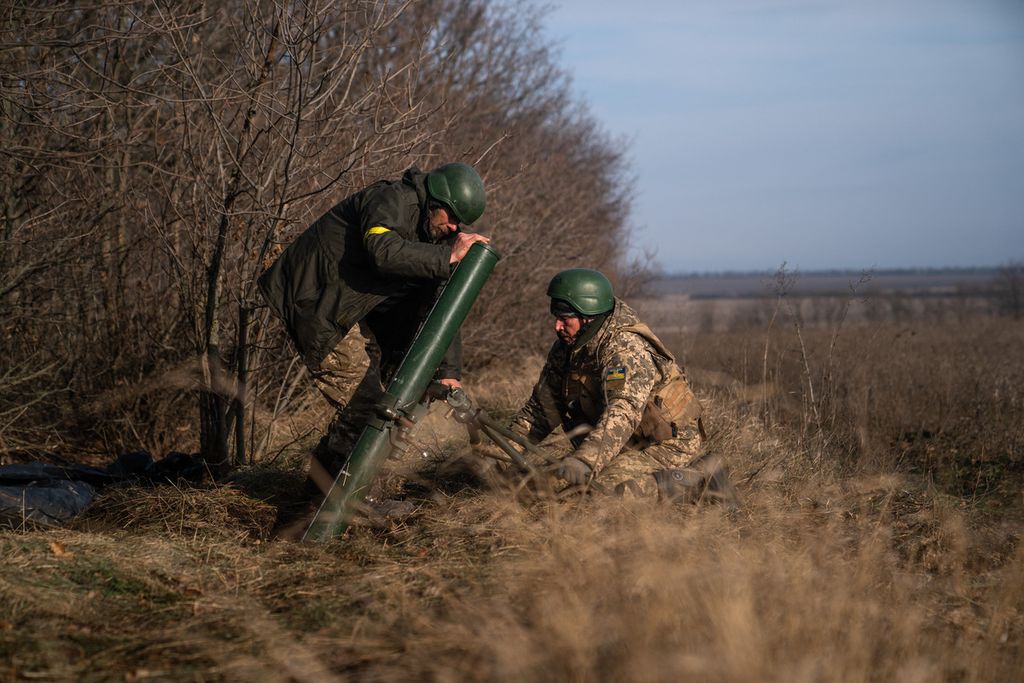 Dua anggota pasukan Ukraina tengah mempersiapkan meluncurkan mortar ke posisi militer Rusia di di sebuah lokasi di Bakhmut, wilayah Donetsk, Ukraina, Jumat (9/12/2022). Militer Rusia melancarakan serangan ke wilayah ini dan mencoba untuk mengontrolnya setelah mereka kehilangan kendali atas Kherson. 