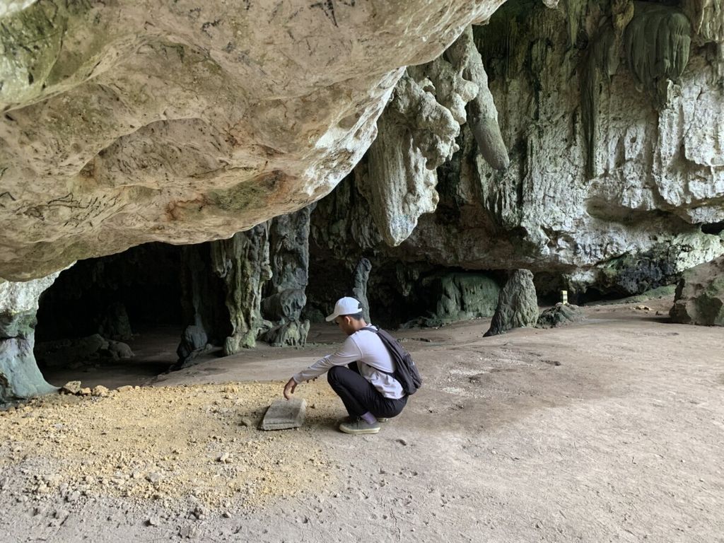 Seorang pengunjung melihat lubang bekas ekskavasi di mulut Liang Panninge (Gua Kelelawar) di Kecamatan Mallawa, Maros, Sulawesi Selatan. Penggalian di tempat ini menemukan kerangka manusia dengan DNA Dinosovan.