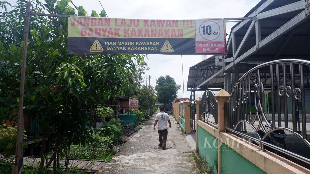 Warga menyusuri jalan beton di Desa Pulau Sewangi, Kecamatan Alalak, Kabupaten Barito Kuala, Kalimantan Selatan, Sabtu (9/3/2024). Pulau Sewangi dikenal sebagai sentra pembuatan perahu tradisional yang berlangsung sejak lama secara turun-temurun.