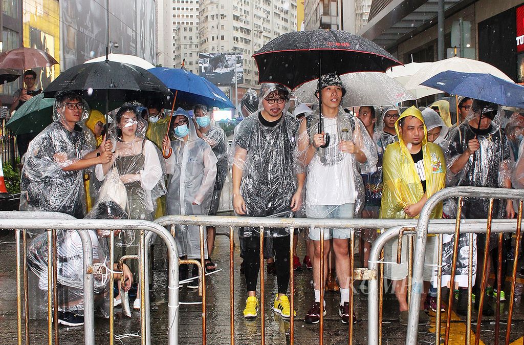 Di bawah guyuran hujan para demonstran pro demokrasi yang terdiri atas pelajar dan pekerja menduduki jalan Hennesy, Distrik Wanchai, Hong Kong, yang dipadati pertokoan fashion dunia, Jumat (3/10), di bawah guyuran hujan. Sebelumnya jalan ini masih dilalui lalu lintas kendaraan. Demonstran menduduki jalan itu bertujuan untuk memaksa pemerintah berdialog dengan demonstran. 