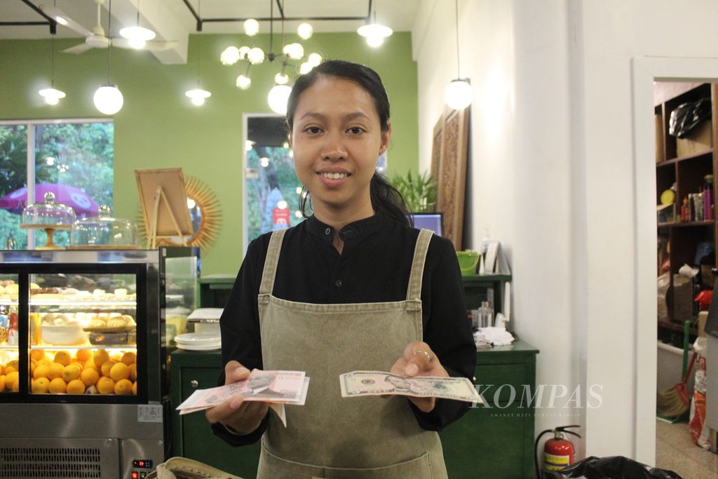 Kamboja menggunakan dua mata uang dalam kehidupan sehari-hari, yakni riel dan dollar AS, seperti yang ditunjukkan salah satu pelayan kafe di Wat Phnom, Phnom Penh, Rabu (3/5/2023).