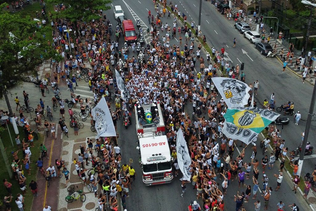 Warga berkerumun di sepanjang jalan yang dilewati iring-iringan kendaraan pembawa jenazah Pele menuju tempat pemakaman Santos Memorial di Santos, Sao Paulo, Brasil, Selasa (3/1/2023). 