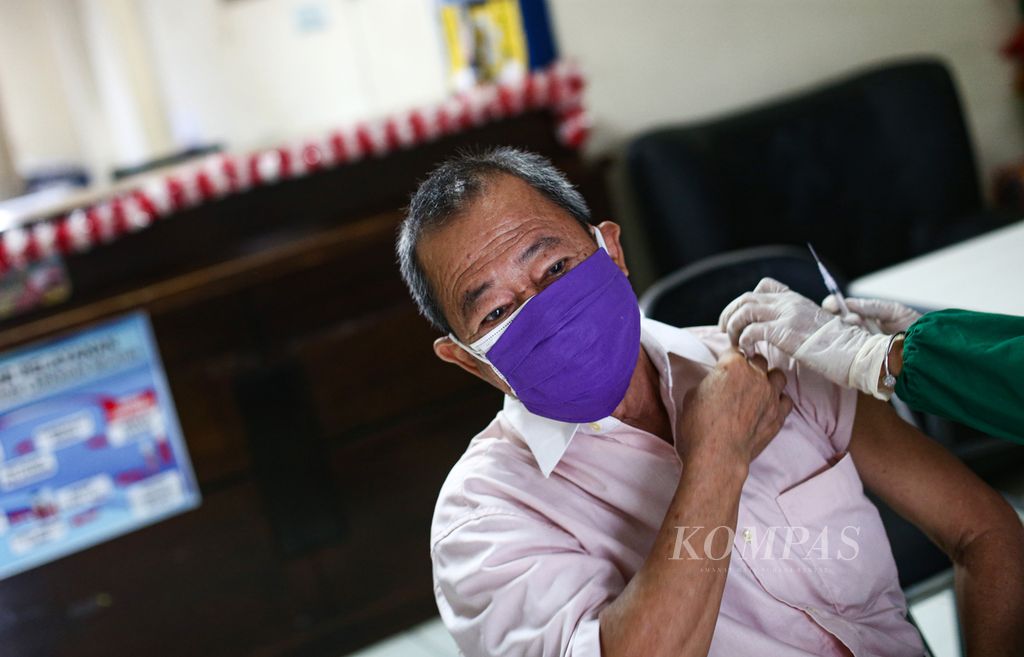 Seorang warga lanjut usia menerima suntikan vaksin Covid-19 penguat di sentra vaksin di Kelurahan Larangan Selatan, Larangan, Kota Tangerang, Banten, Selasa (8/2/2022). 