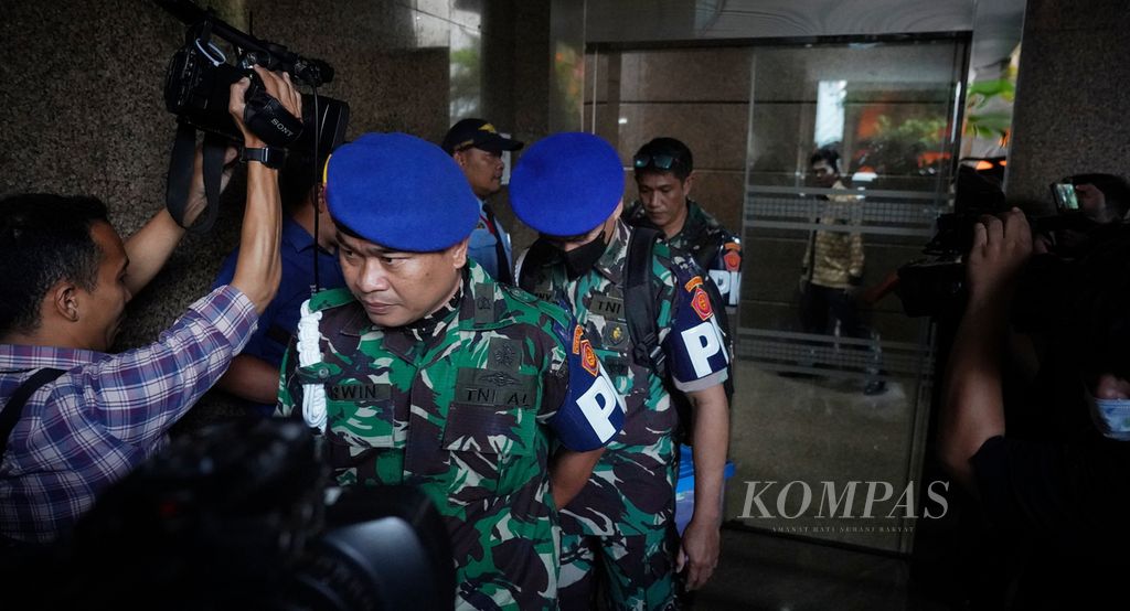 Para petugas Pusat Polisi Militer (Puspom) TNI melintasi pintu keluar setelah bersama penyidik KPK melakukan penggeledahan di gedung Kantor Basarnas, Kemayoran, Jakarta, Jumat (4/8/2023). 