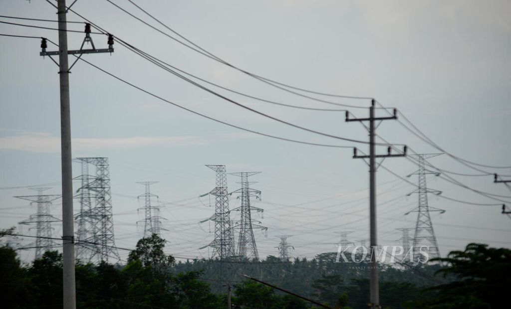 Deretan tiang listrik yang disiapkan untuk kawasan industri dengan latar belakang jaringan saluran udara tegangan ekstratinggi di Kecamatan Tulis, Kabupaten Batang, Jateng, Senin (13/6/2022).
