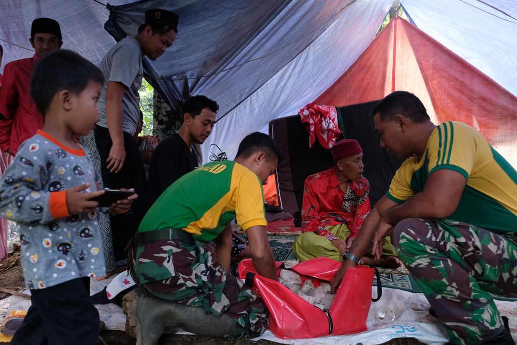 Sejumlah warga mengatre untuk mendapatkan makanan yang telah disiapkan oleh prajurit dari Yon Bekang 1 Kostrad Cibinong di Kampung Cileungsi, Desa Sukajaya, Kecamatan Cugenang, Kabupaten Cianjur, Selasa (29/11/2022).  