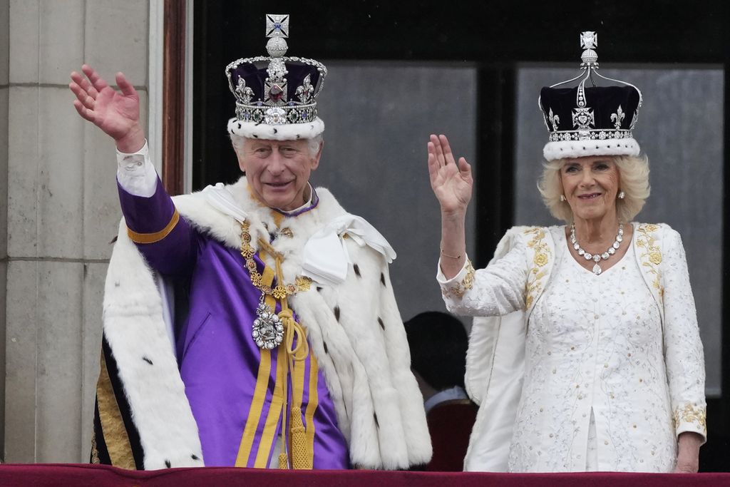 Raja Inggris Charles III dan Permaisuri Camilla melambaikan tangan ke arah warga dari balkon Istana Buckingham seusai upacara penobatan keduanya di London, Sabtu (6/5/2023). 