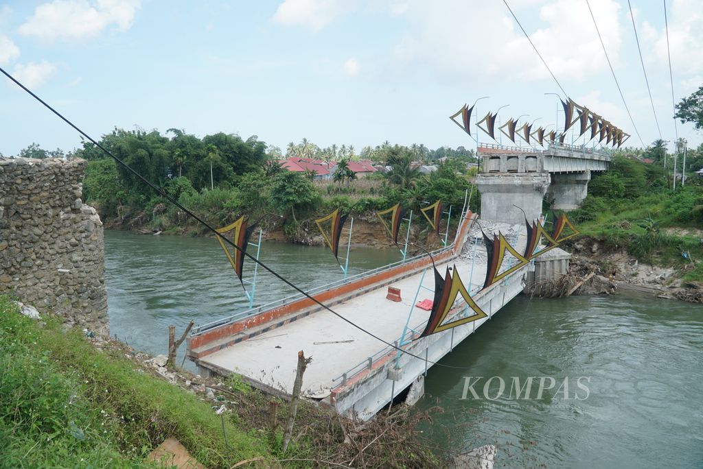 Kondisi Jembatan Kayu Gadang yang ambruk setelah sekitar dua tahun dibangun difoto dari Korong Kayu Gadang Koto Buruak, Nagari Lubuk Alung, Kecamatan Lubuk Alung, Padang Pariaman, Sumbar, Selasa (16/5/2023). Jembatan penghubung dua nagari di Kecamatan Lubuk Alung, yaitu Lubuk Alung dan Balah Hilia Lubuk Alung, ini roboh akibat tergerus tingginya curah hujan dan besar debit air Sungai Anai pada Minggu (7/5/2023) malam. Jembatan sepanjang 101,8 meter dan lebar 7 meter di jalan kabupaten ini dibangun dengan anggaran Rp 25,4 miliar dari dana hibah rehabilitasi dan rekonstruksi BNPB.