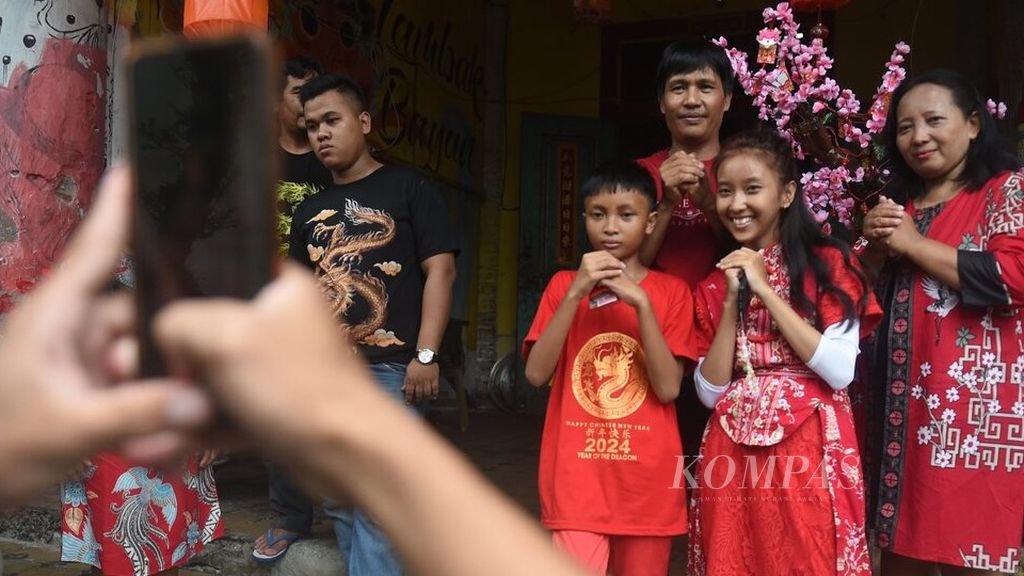 Satu keluarga berfoto bersama saat hari raya Imlek di Pecinan Tambak Bayan, Surabaya, Sabtu (10/2/2024). Walau hidup dalam kesederhanaan, warga Tambak Bayan tetap merayakan Imlek dengan sukacita. Dalam kesempatan tersebut mereka berkumpul bersama keluarga besar. 