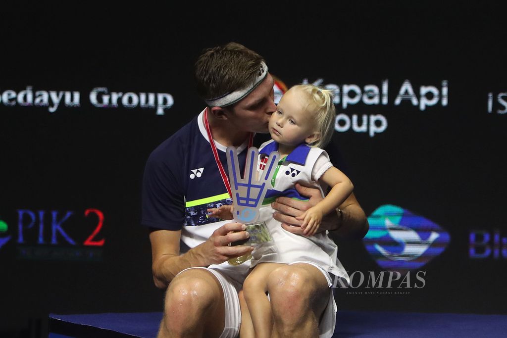 Danish badminton player, Viktor Axelsen, kisses his son, Vega Rohde Axelsen, during the awarding of medals and prizes for the East Ventures Indonesia Open 2022 champion at Istora Gelora Bung Karno, Jakarta, Sunday (19/6/2022). Axelsen won the final match against Zhao Jun Peng (China) 21-9, 21-10.