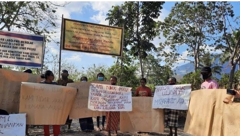Masyarakat adat Rendu Nagekeo membentangkan spanduk berisikan penolakan pembangunan Bendungan Lambo karena proses pembangunan itu mengabaikan hak-hak masyarakat adat.