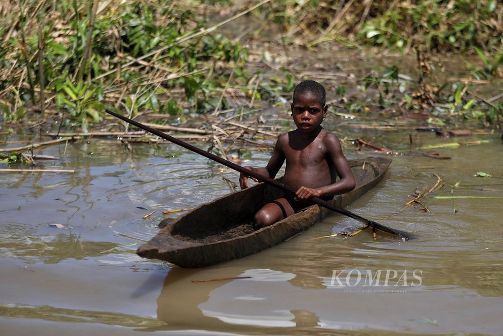  Seorang anak belajar mengendalikan perahu di sungai yang mengelilingi Kampung Er, Distrik Sawaerma, Kabupaten Asmat, Papua, Rabu (13/10/2021).