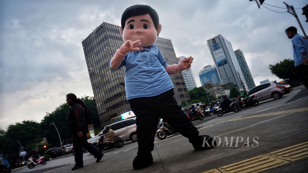 Boneka kostum ikon Gemoy yang dihadirkan Tim Kampanye Nasional (TKN) Fanta Prabowo-Gibran berjoget-joget di persimpangan Sarinah, Jakarta, saat berkampanye, Jumat (29/12/2023). Kampanye yang dilakukan tim milenial pendukung Prabowo-Gibran ini menyajikan Joget Gemoy di hadapan publik di kawasan tersebut.  