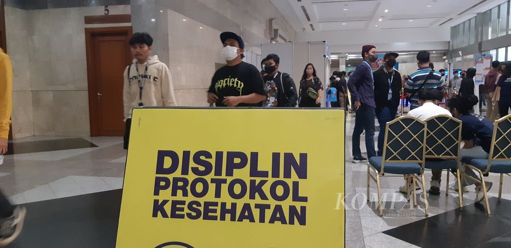 Peringatan disiplin protokol kesehatan ditempatkan di pintu masuk pameran busana tren JakCloth di Jakarta Convention Center, Senayan, Jakarta Pusat, Minggu (24/4/2022).