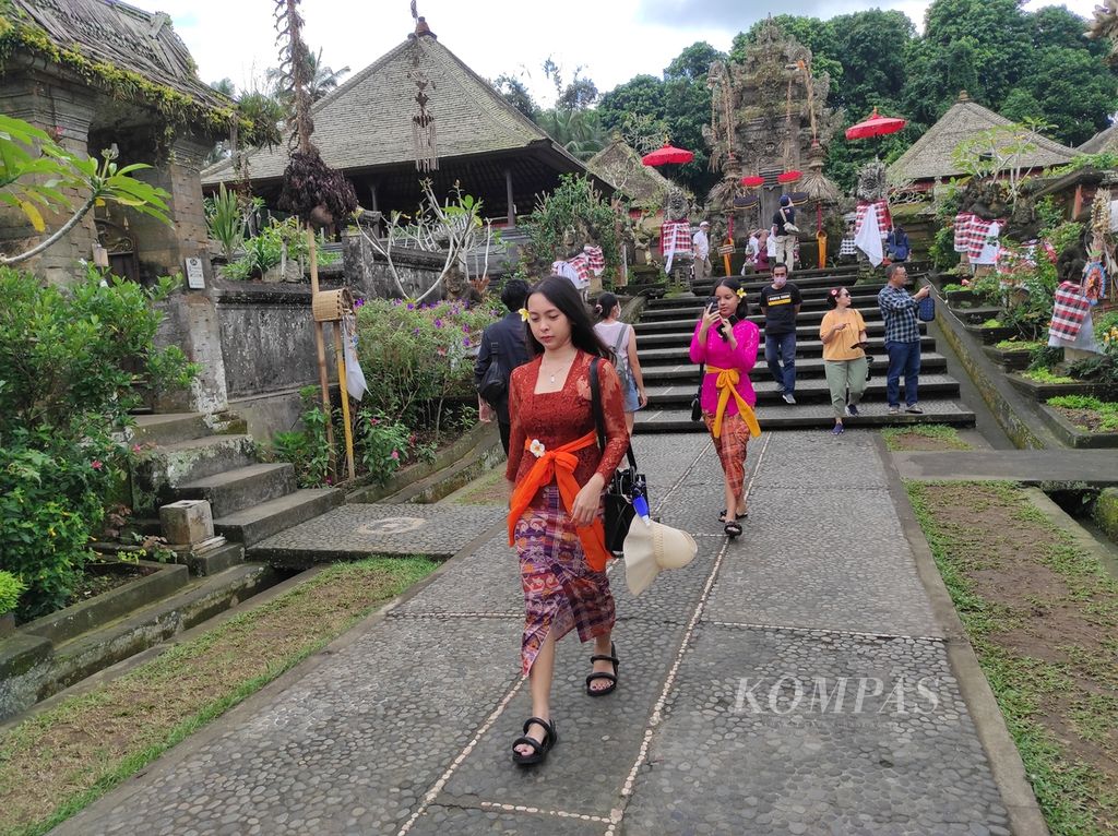 Pengunjung tengah membuat sebuah konten video di Desa Adat Penglipuran, Kabupaten Bangli, Bali, Selasa (28/6/2022). Selain melihat rumah-rumah adat khas Bali, wisatawan juga bisa menyewa baju ada Bali untuk melengkapi momen berada di desa wisata itu.