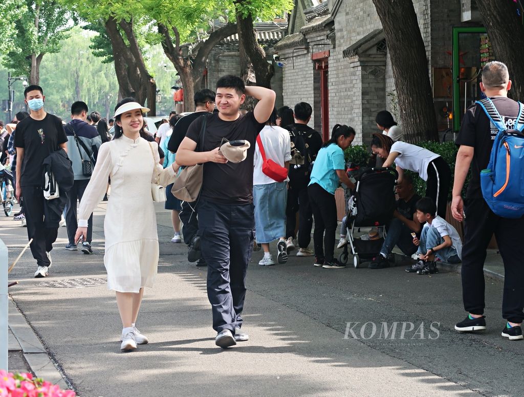 Seorang perempuan (kiri) terlihat mengenakan <i>qipao </i>atau <i>cheongsam </i>saat berkunjung ke Shichahai, di Distrik Xicheng, Beijing, China, Selasa (2/5/2023). 