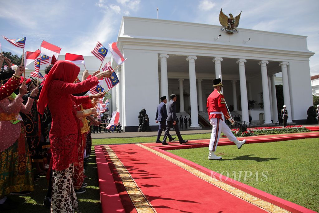 Presiden Joko Widodo bersama Perdana Menteri Malaysia Anwar Ibrahim berjalan bersama dalam upacara penyambutan di Istana Kepresidenan, Bogor, Jawa Barat, Senin (9/1/2023). Ini merupakan kunjungan pertama Anwar Ibrahim sebagai Perdana Menteri Malaysia setelah pelantikan 24 November lalu. 