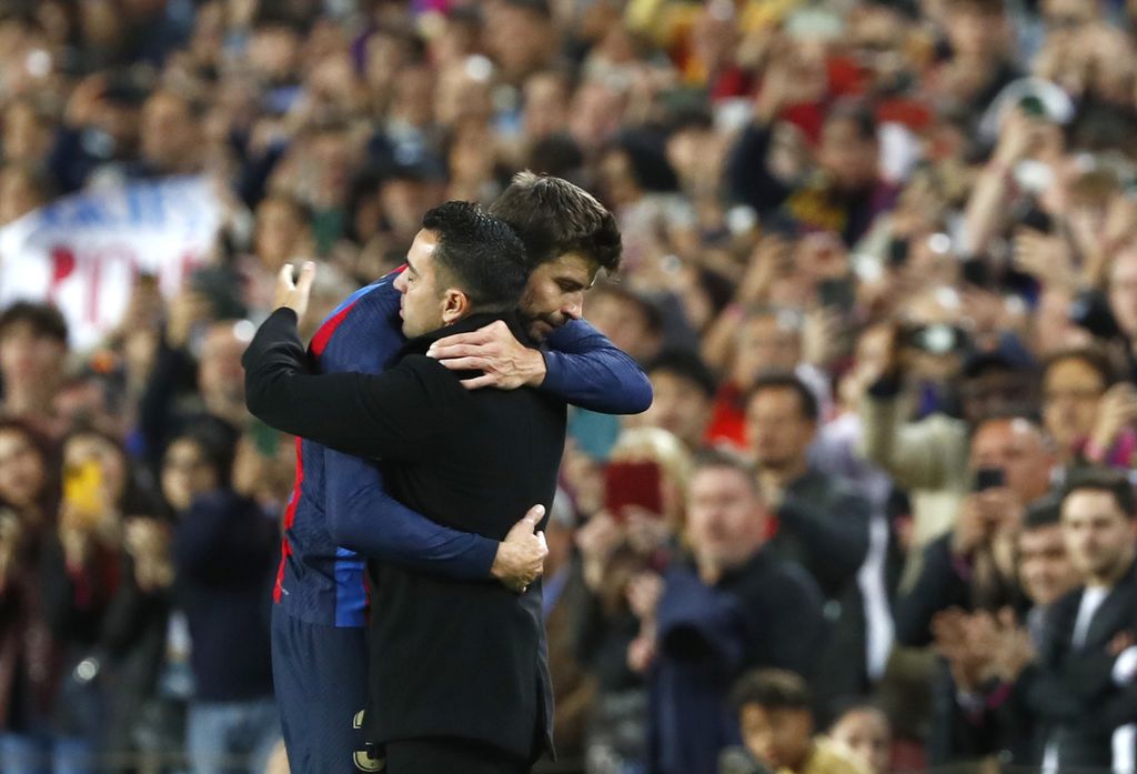 Pemain Barcelona, Gerard Pique, dan Pelatih Barcelona Xavi Hernandez berpelukan seusai laga Liga Spanyol melawan Almeria di Stadion Camp Nou, Barcelona. Pique mengumumkan keputusannya pensiun seusai laga tersebut. 