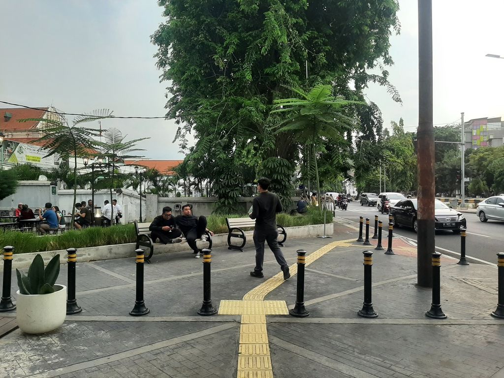 Warga duduk di bangku yang tersedia pada jalur pedestrian di kawasan Sawah Besar, Jakarta Pusat, Senin (3/10/2022).